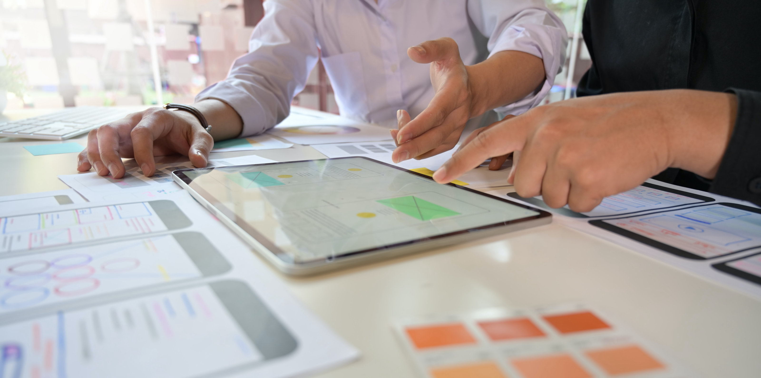 Two people collaborating with a tablet on a table